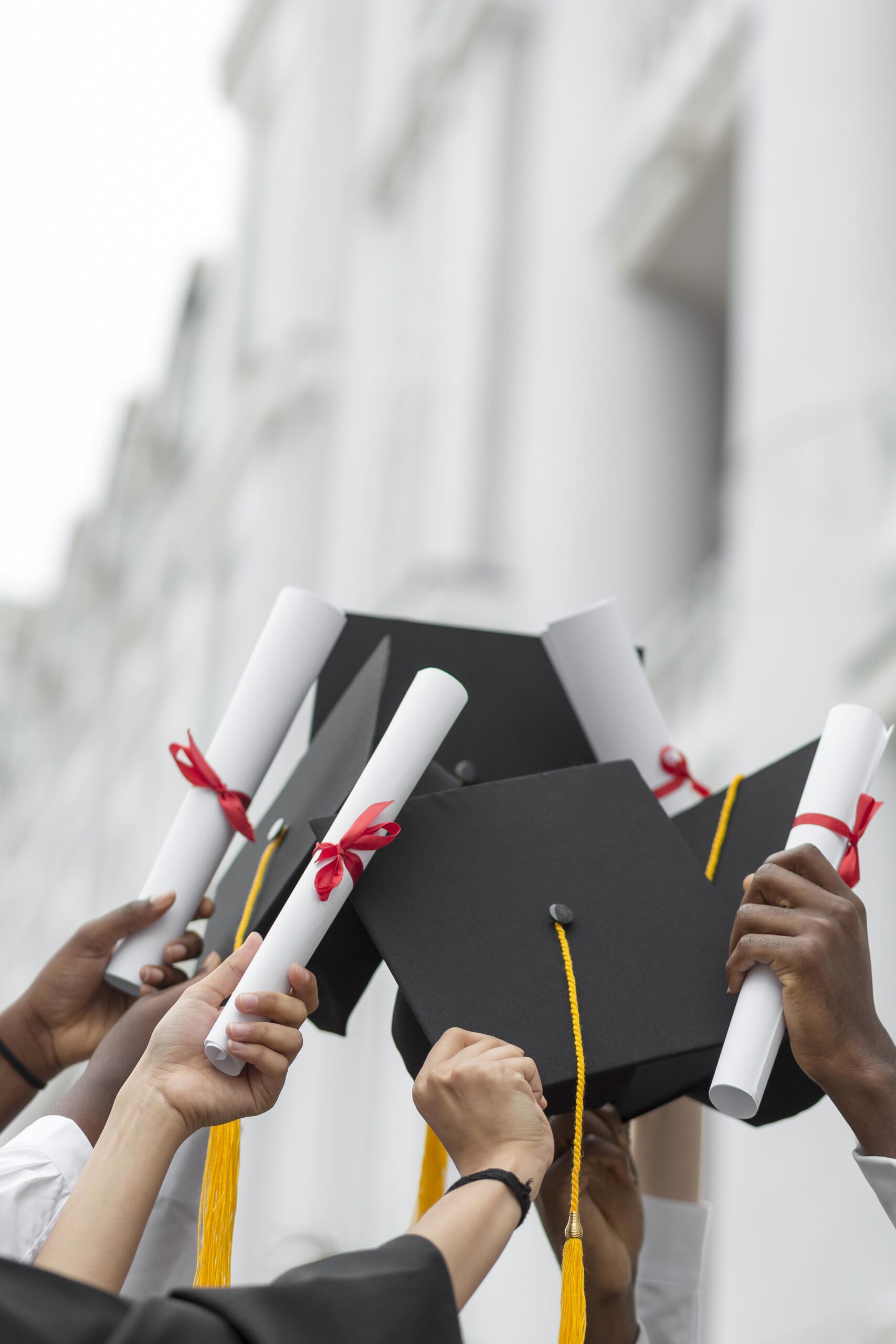 close-up-hands-holding-diplomas-and-caps